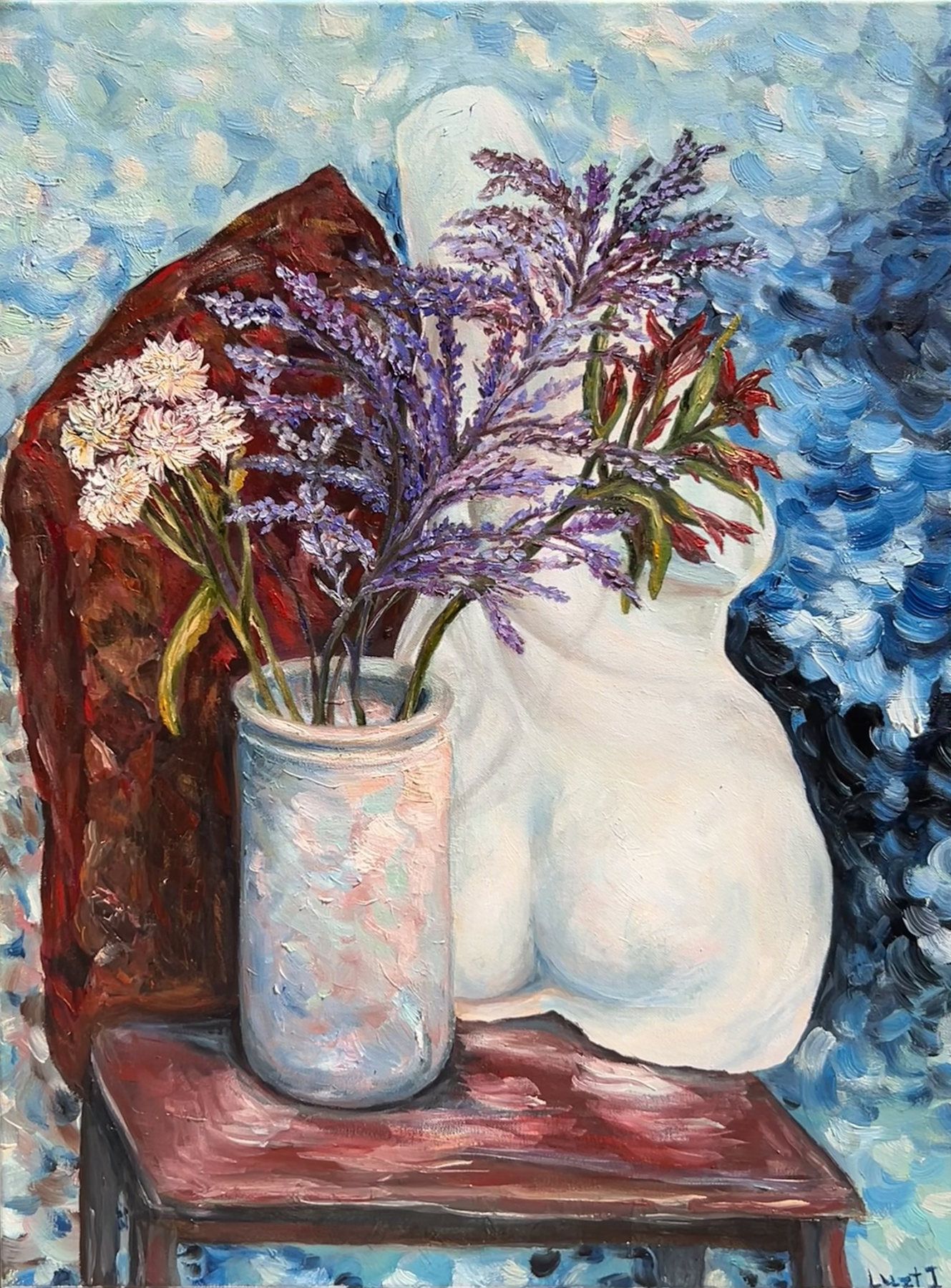 Pale sculptural figure behind a vase of wild flowers on a red-draped table against blue shadows.