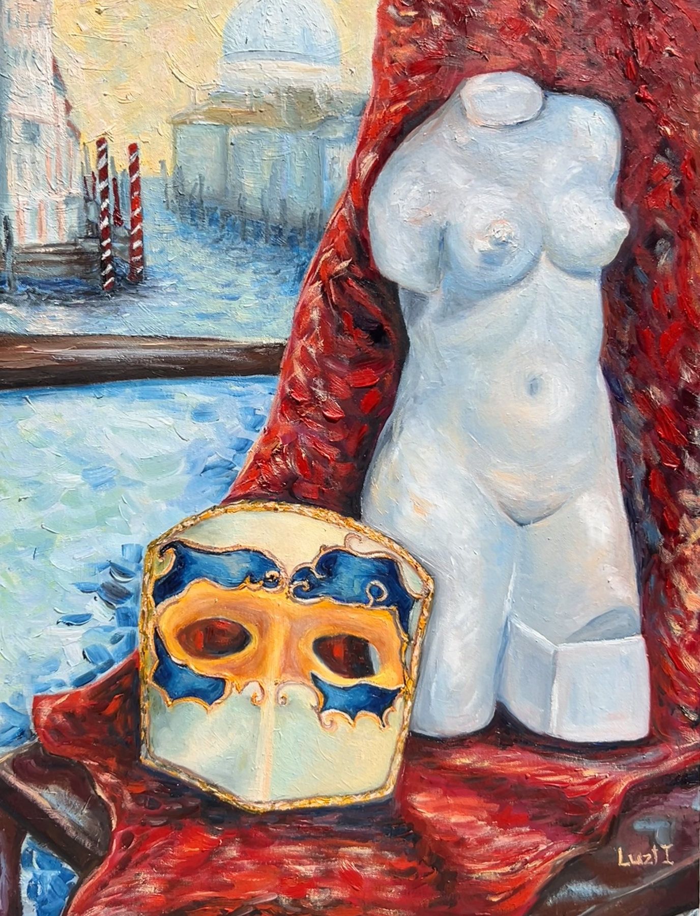 White sculptural female torso and gold-blue carnival mask against red drapery and a canal view.