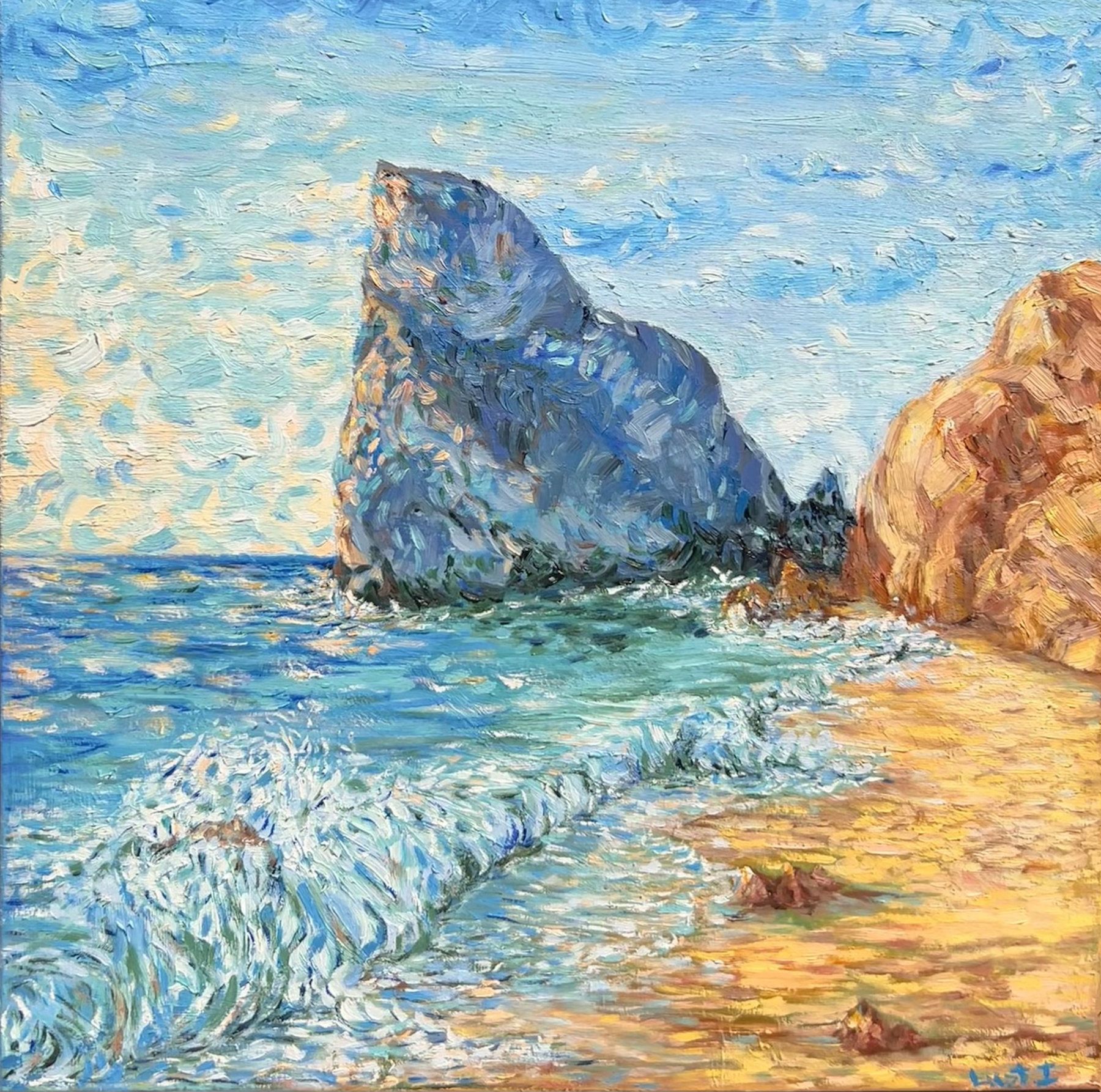 Blue sea breaking onto a golden beach beside tall rocky cliffs under a bright sky.
